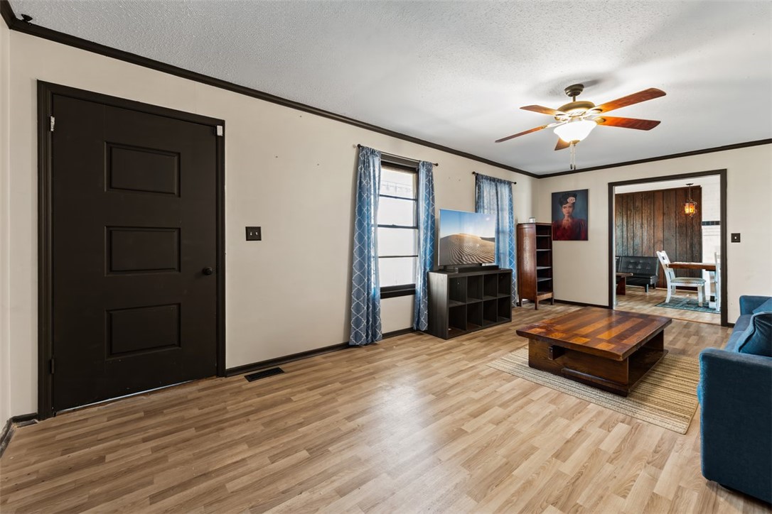 606 County Rd S-1-149 Donalds, SC 29638 - Photo 5 of 38 This inviting living area features warm flooring and a ceiling fan, creating a comfortable atmosphere.
