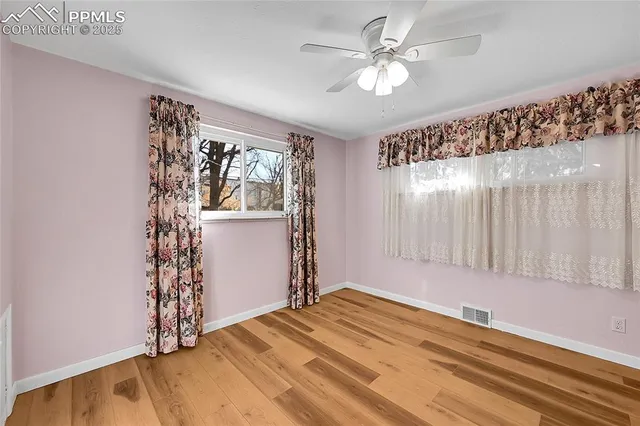 a view of a bedroom with window and ceiling fan