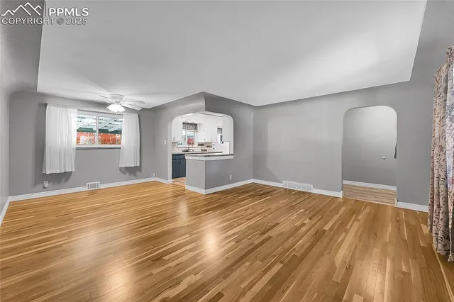 a view of empty room with wooden floor