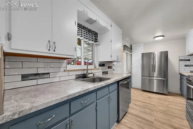 a kitchen with stainless steel appliances a sink and a refrigerator
