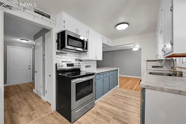 a kitchen with stainless steel appliances granite countertop a stove a sink and a microwave