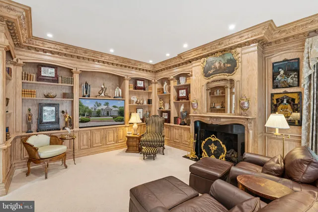 a living room with furniture a fireplace and large windows