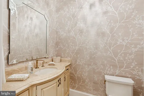 a bathroom with a granite countertop sink a toilet and a mirror