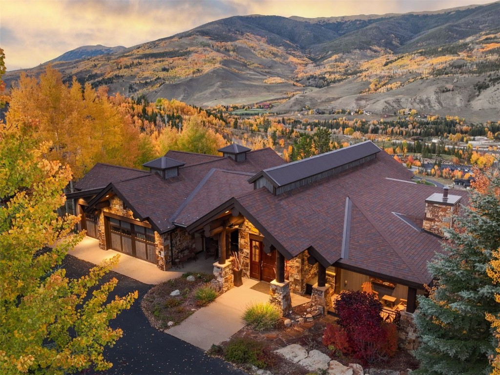 an aerial view of house with yard and mountain view in back