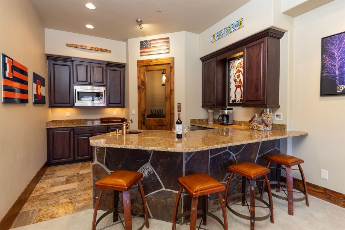 1330 Golden Eagle Road Silverthorne, CO 80498 - Photo 23 of 41 a kitchen with stainless steel appliances kitchen island granite countertop a sink and cabinets