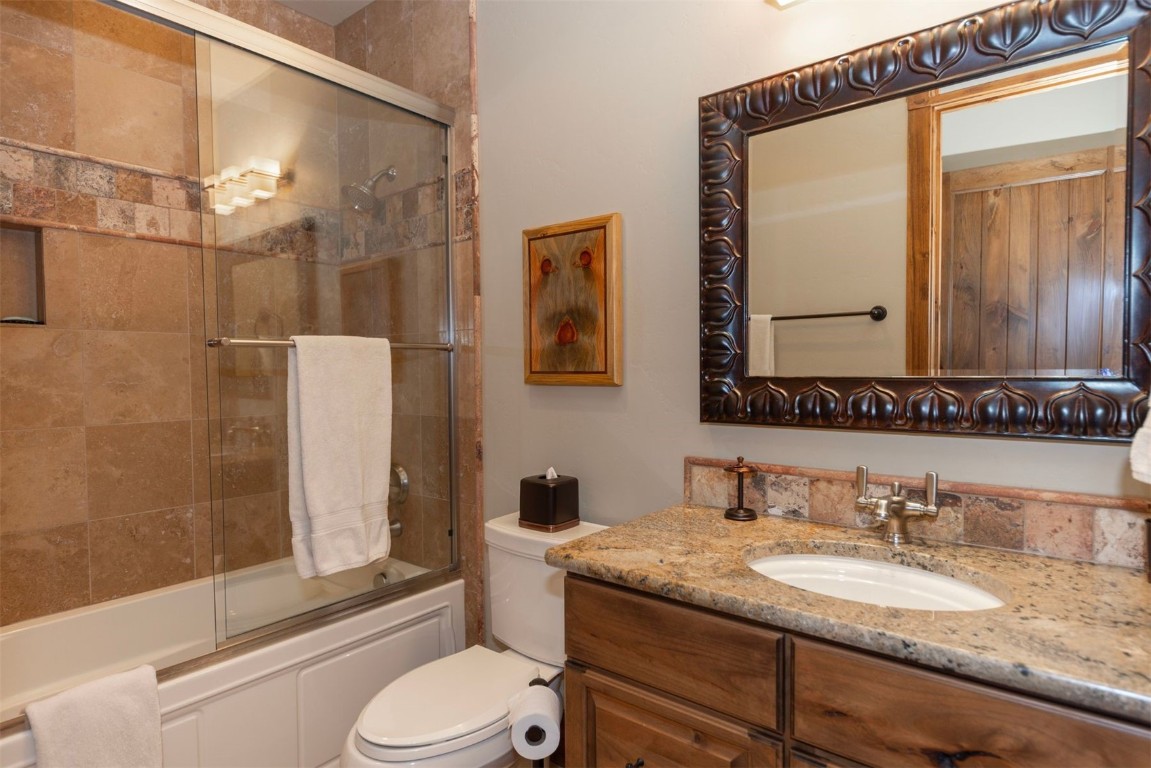 1330 Golden Eagle Road Silverthorne, CO 80498 - Photo 27 of 41 a bathroom with a granite countertop sink toilet and shower