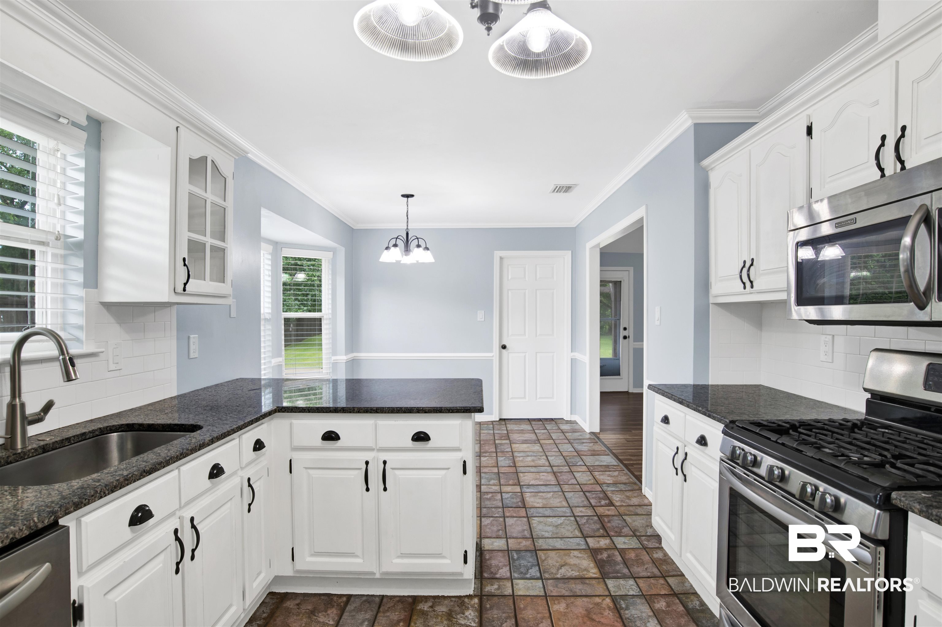 3011 Olde Gate Road Mobile, AL 36695 - Photo 19 of 35 Kitchen with appliances with stainless steel finishes, tasteful backsplash, white cabinets, dark stone finish floors, and ornamental molding