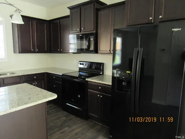 an empty room with wooden floor fireplace and windows