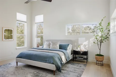 a bedroom with a large bed and a potted plant