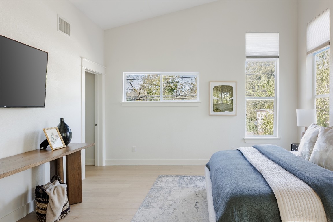 1205 McKinley Avenue Austin, TX 78702 - Photo 21 of 34 a bedroom with a bed and a flat tv screen on the dresser