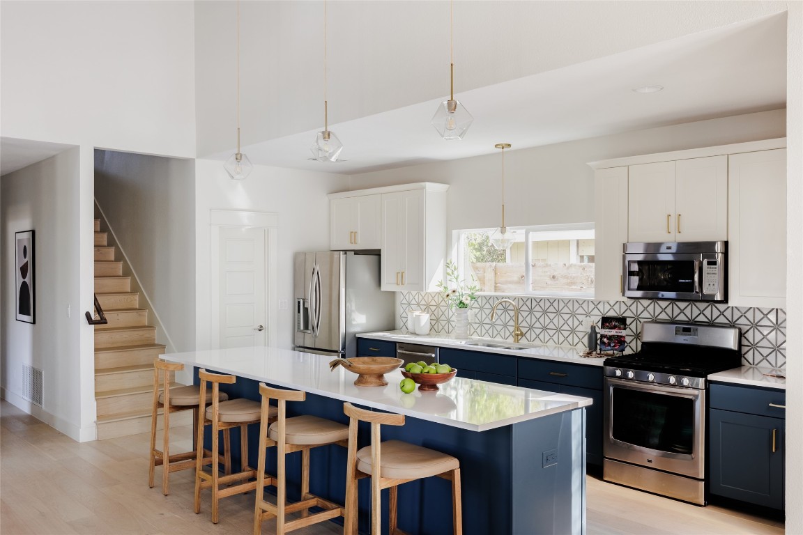 1205 McKinley Avenue Austin, TX 78702 - Photo 9 of 34 a kitchen with stainless steel appliances granite countertop a stove a refrigerator a sink a dining table and chairs