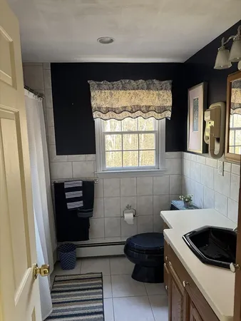 a bathroom with a sink a toilet and a window