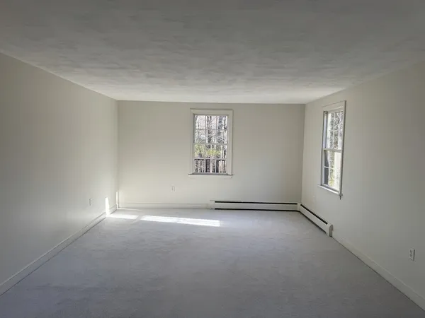 an empty room with windows and closet