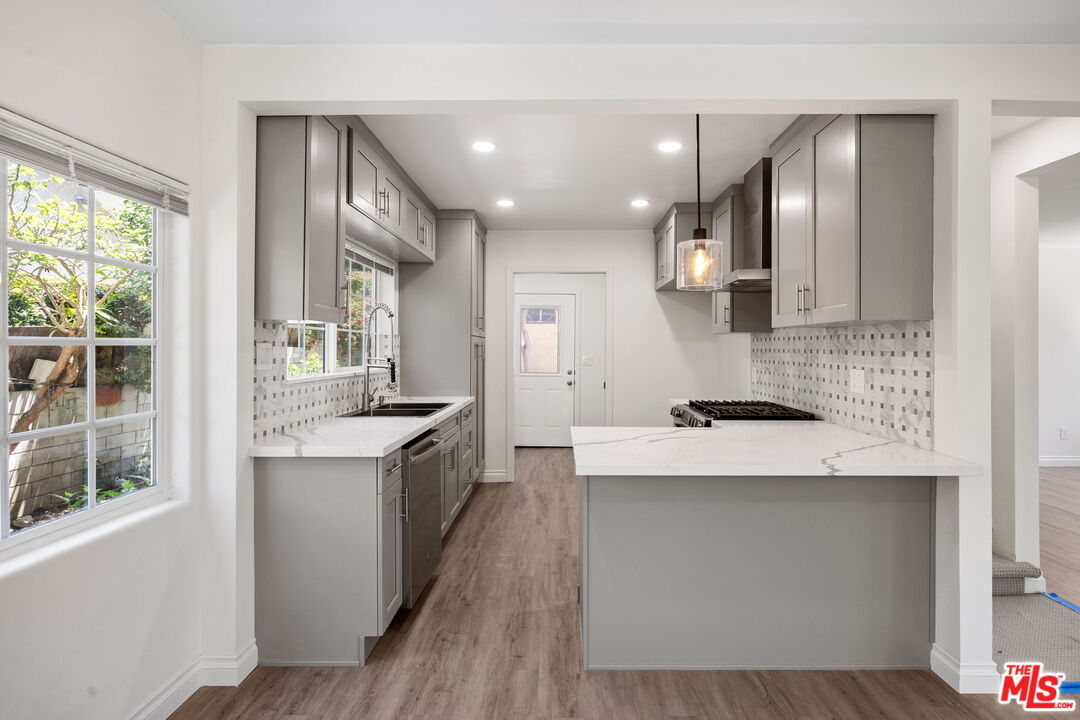 1342 Mohawk Street Los Angeles, CA 90026 - Photo 13 of 29 a large kitchen with stainless steel appliances granite countertop a sink a stove and a refrigerator