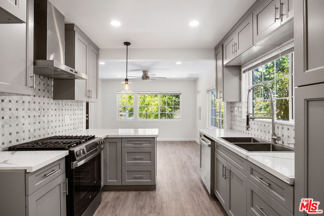 1342 Mohawk Street Los Angeles, CA 90026 - Photo 15 of 29 a kitchen with kitchen island granite countertop a stove a sink and a wooden floors