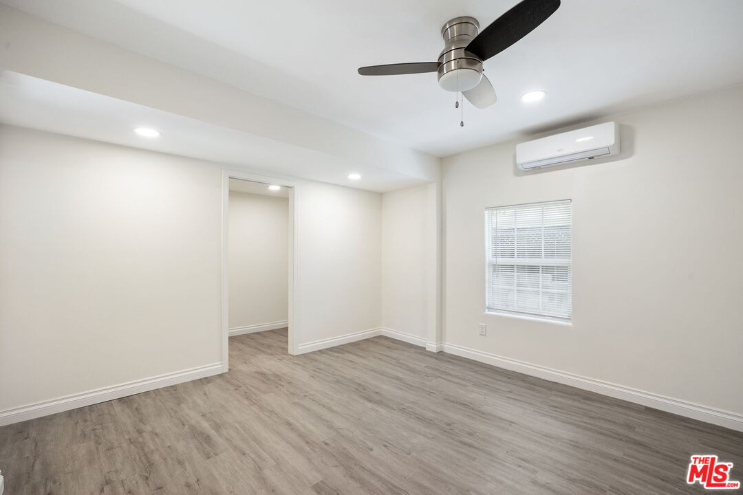 1342 Mohawk Street Los Angeles, CA 90026 - Photo 19 of 29 an empty room with wooden floor ceiling fan and windows