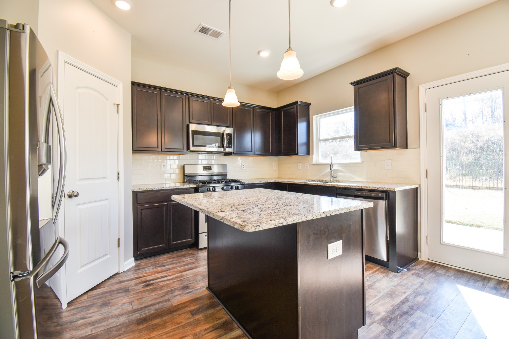 525 Burchell Lane Columbia, TN 38401 - Photo 11 of 29 a kitchen with kitchen island granite countertop stainless steel appliances a sink cabinets and a window