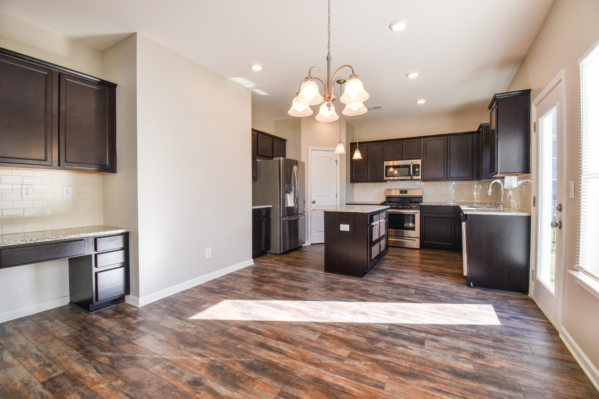 525 Burchell Lane Columbia, TN 38401 - Photo 9 of 29 a kitchen with stainless steel appliances kitchen island granite countertop a refrigerator a stove top oven a sink dishwasher and a refrigerator with wooden floor