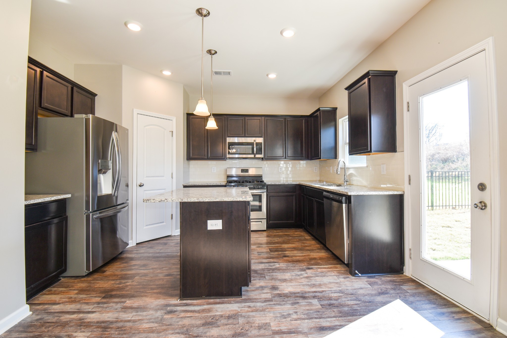 525 Burchell Lane Columbia, TN 38401 - Photo 10 of 29 a kitchen with kitchen island granite countertop a refrigerator stove top oven and sink