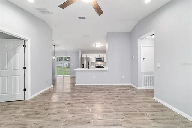 a kitchen with stainless steel appliances kitchen island granite countertop a refrigerator and microwave