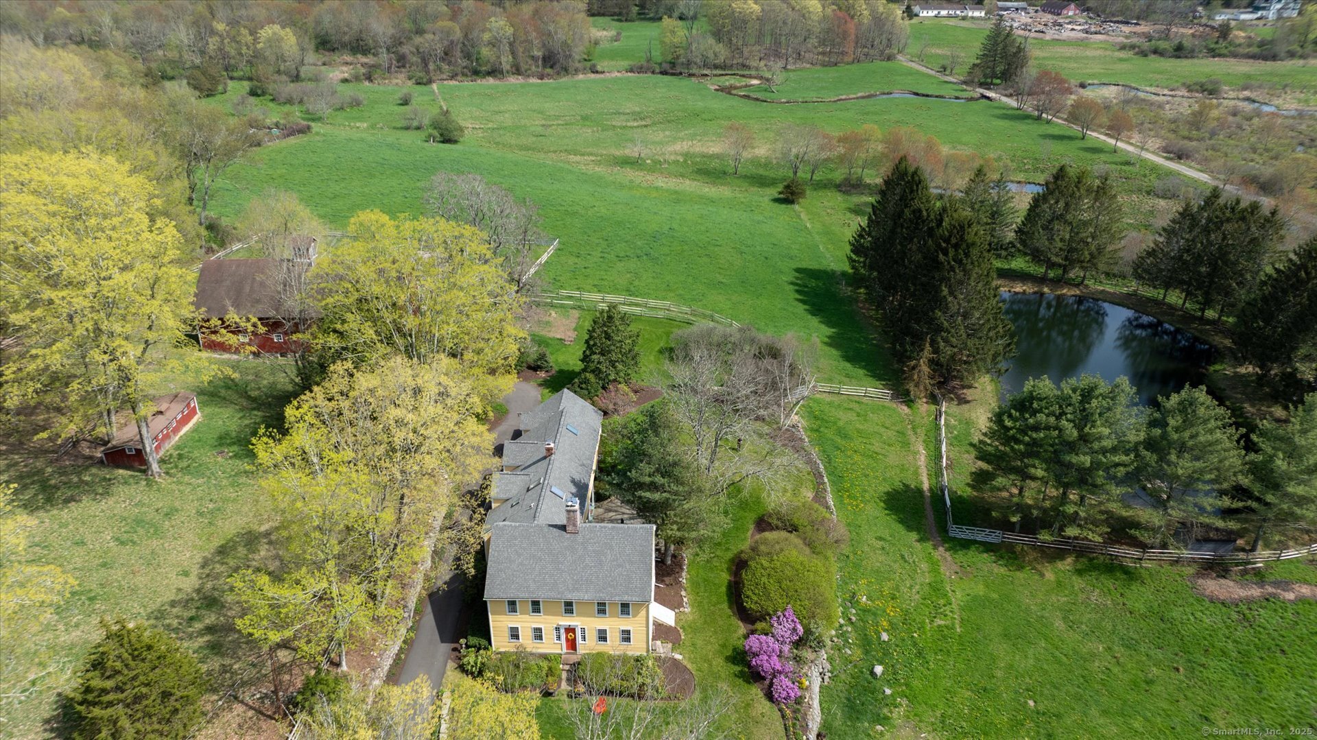 an aerial view of residential house with outdoor space and trees all around
