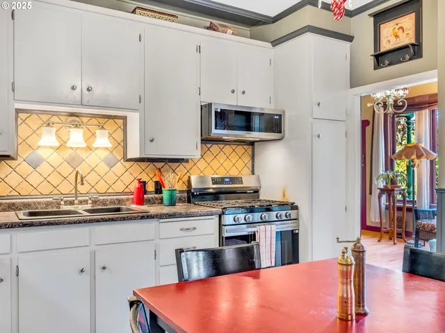 a kitchen with stainless steel appliances a stove a sink and a microwave