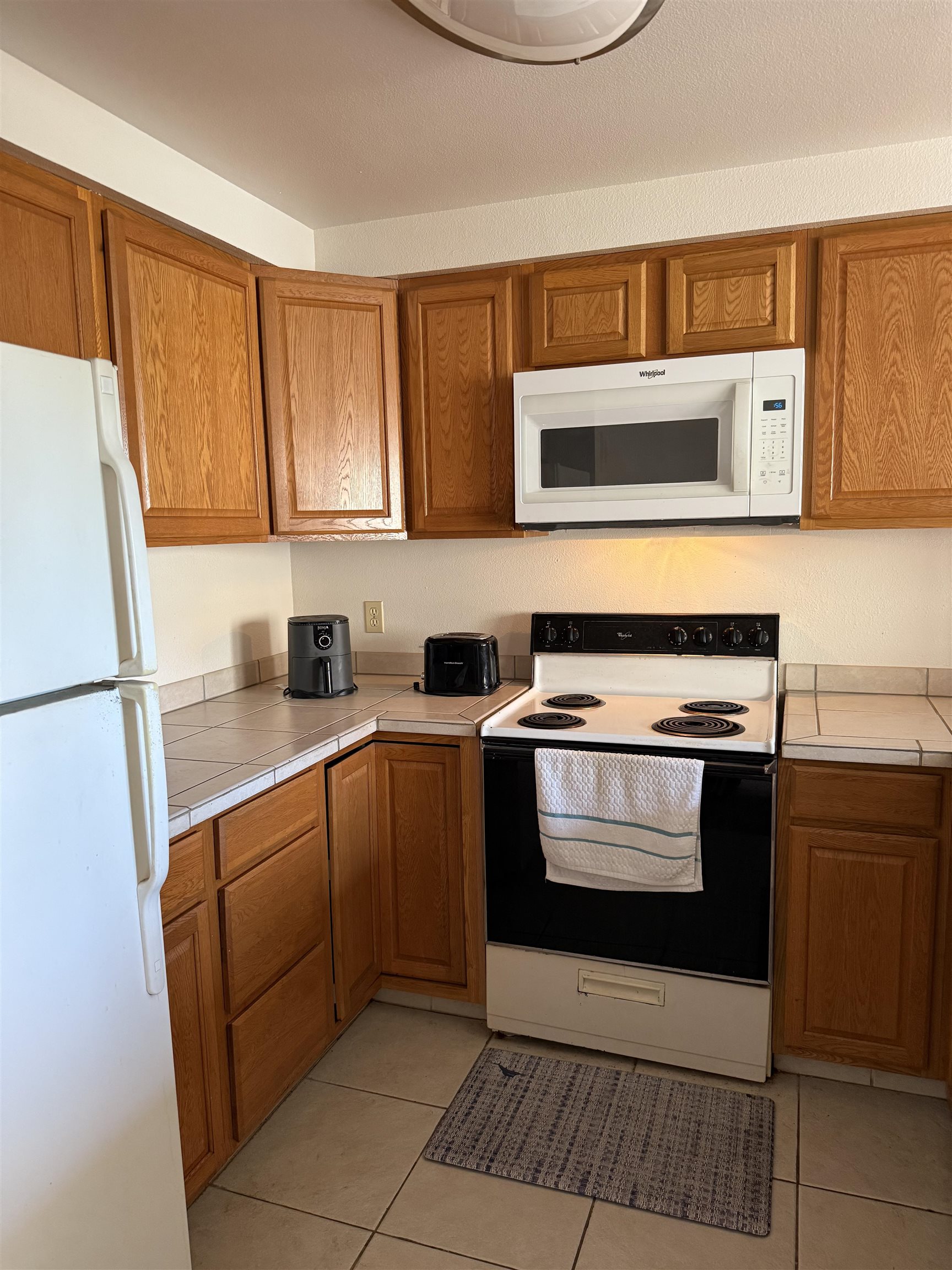 2747 South Kihei Road, Unit A101 Kihei, HI 96753 - Photo 3 of 14 a kitchen with stainless steel appliances granite countertop a stove a sink and a microwave