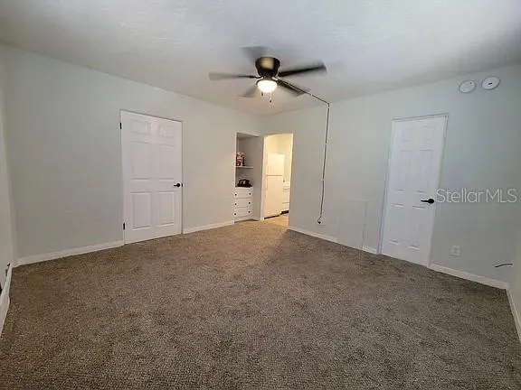 a view of an empty room and a ceiling fan