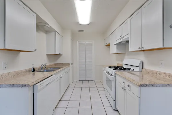 a kitchen with a sink stove and cabinets