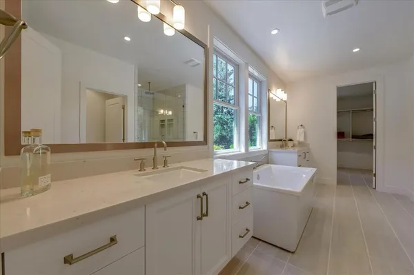 a spacious bathroom with a double vanity sink and a mirror