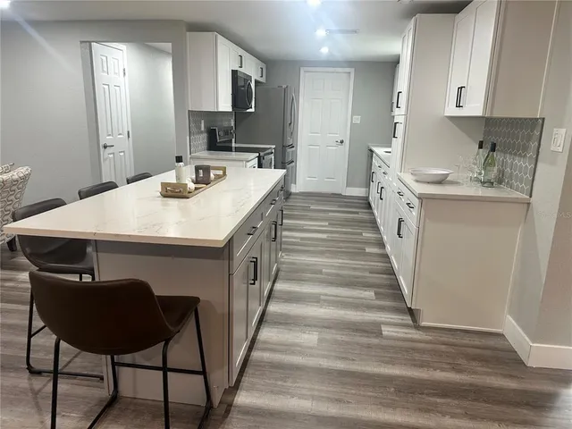 a kitchen with stainless steel appliances a sink a stove a refrigerator and cabinets