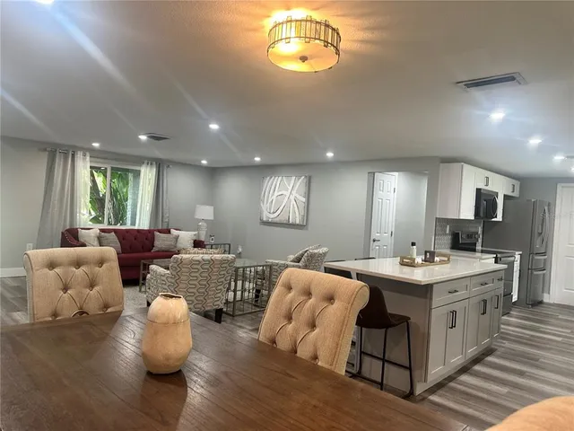 a living room with furniture kitchen view and a window