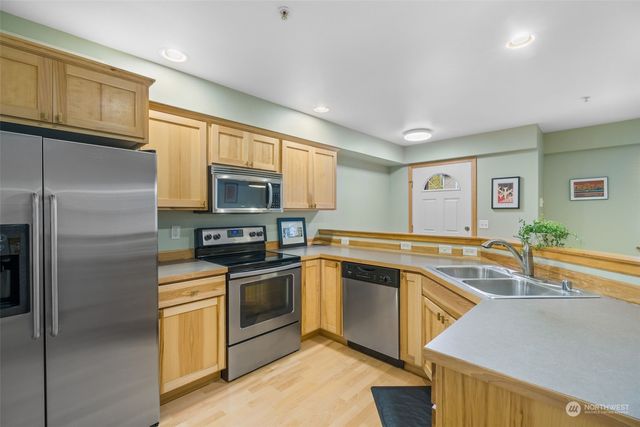 a kitchen with granite countertop stainless steel appliances and wooden cabinets