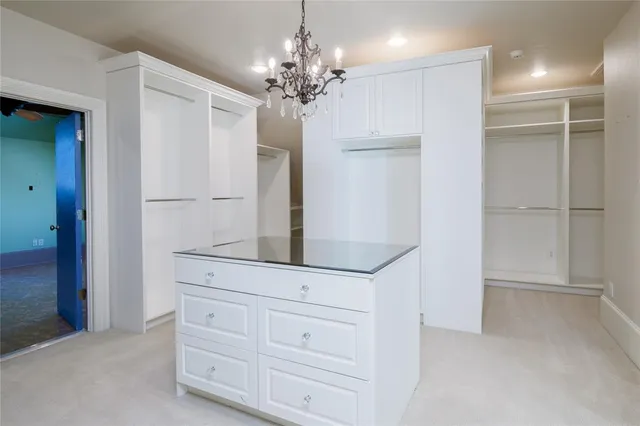 a view of a hallway with front door and chandelier