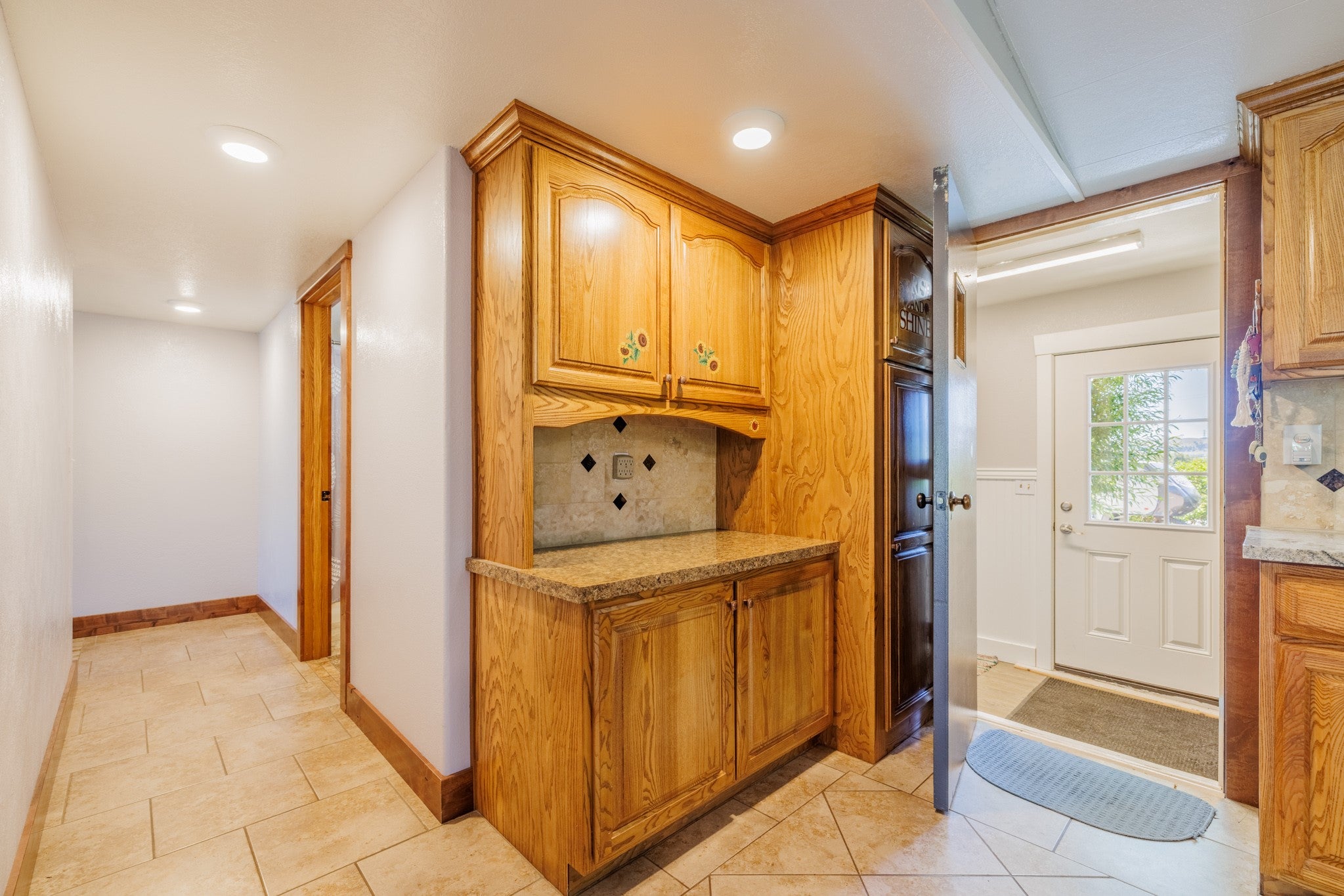 58 Gilman Road Garrison, MT 59731 - Photo 28 of 91 Kitchen featuring tasteful backsplash, brown cabinets, recessed lighting, and light tile patterned floors