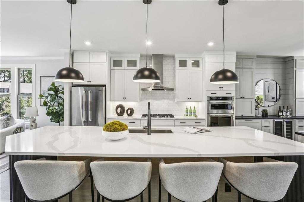 2090 Emmet Park Lane, Unit 425 Decatur, GA 30033 - Photo 3 of 102 a kitchen with kitchen island a dining table chairs and white cabinets