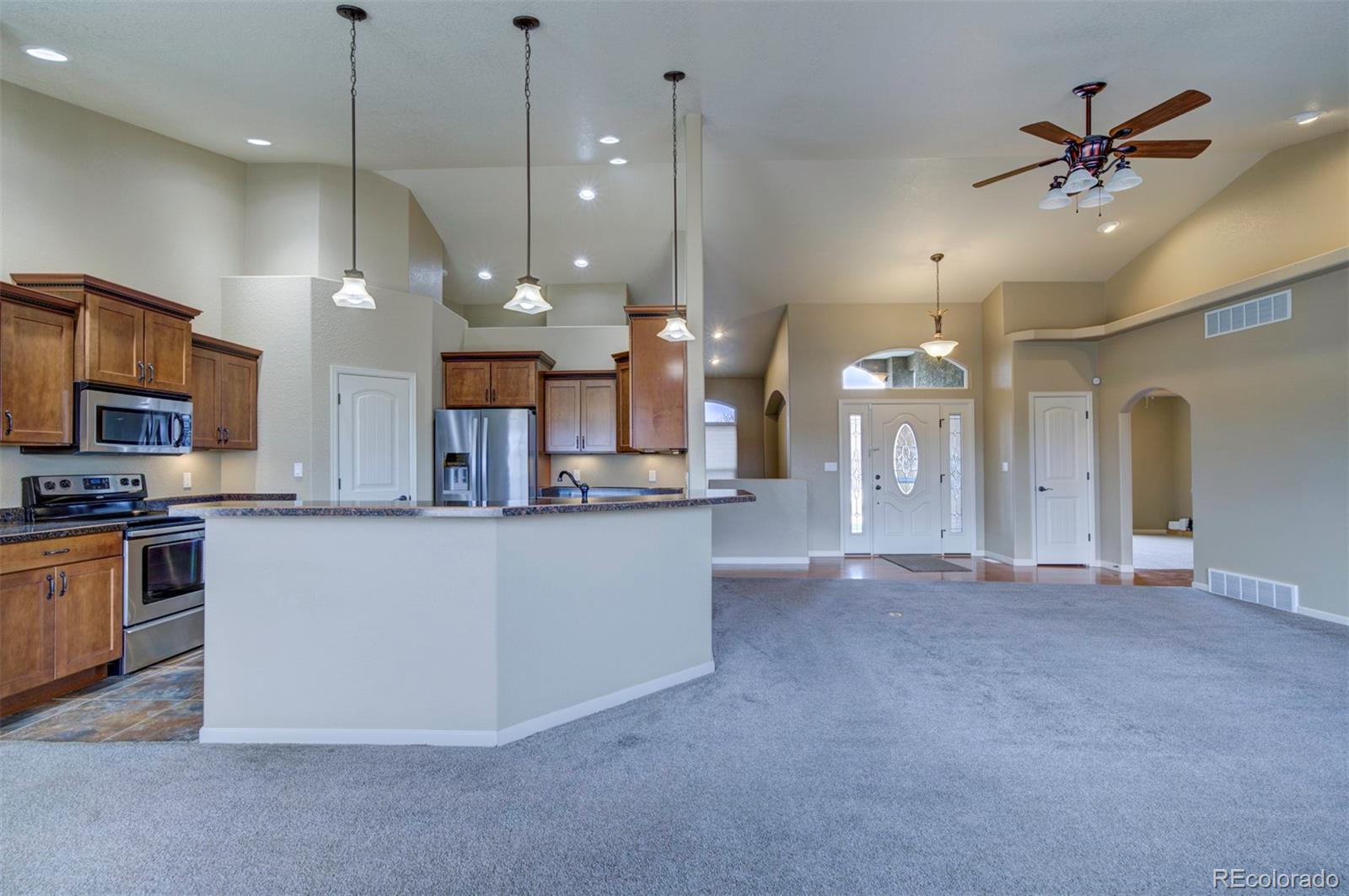 24484 Gale Road Pueblo, CO 81006 - Photo 13 of 43 a view of a kitchen with a stove and a ceiling fan