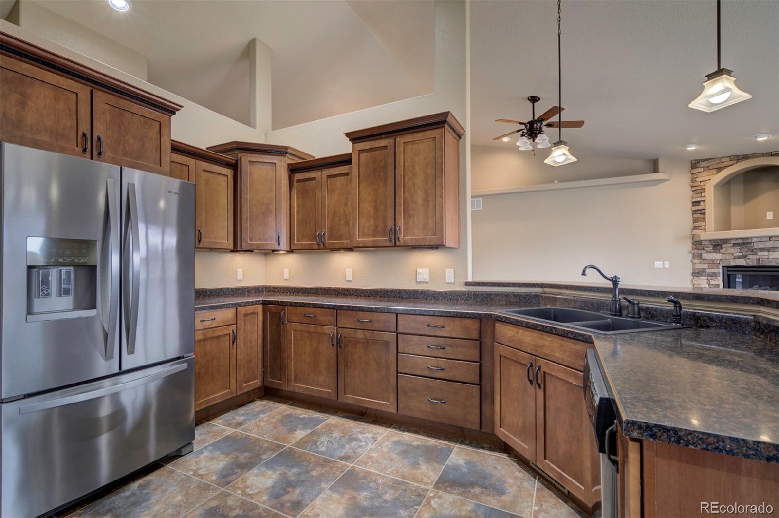 24484 Gale Road Pueblo, CO 81006 - Photo 20 of 43 a kitchen with stainless steel appliances granite countertop a sink stove and refrigerator