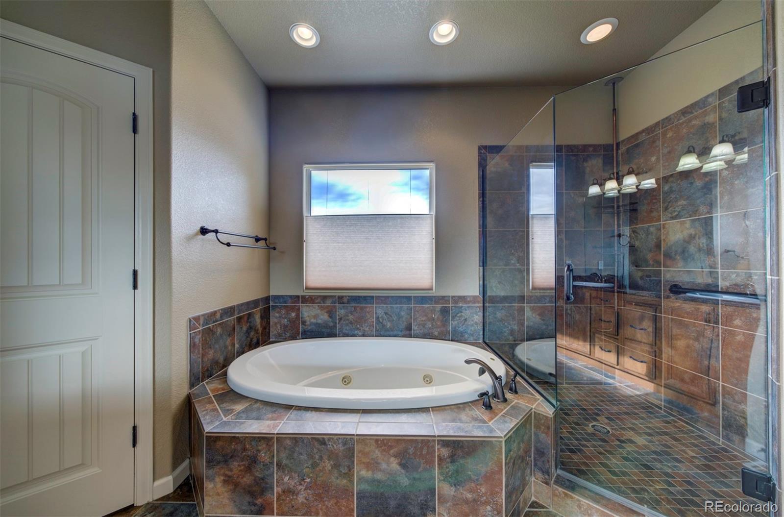 24484 Gale Road Pueblo, CO 81006 - Photo 27 of 43 a bathroom with a granite countertop sink a mirror and a bathtub