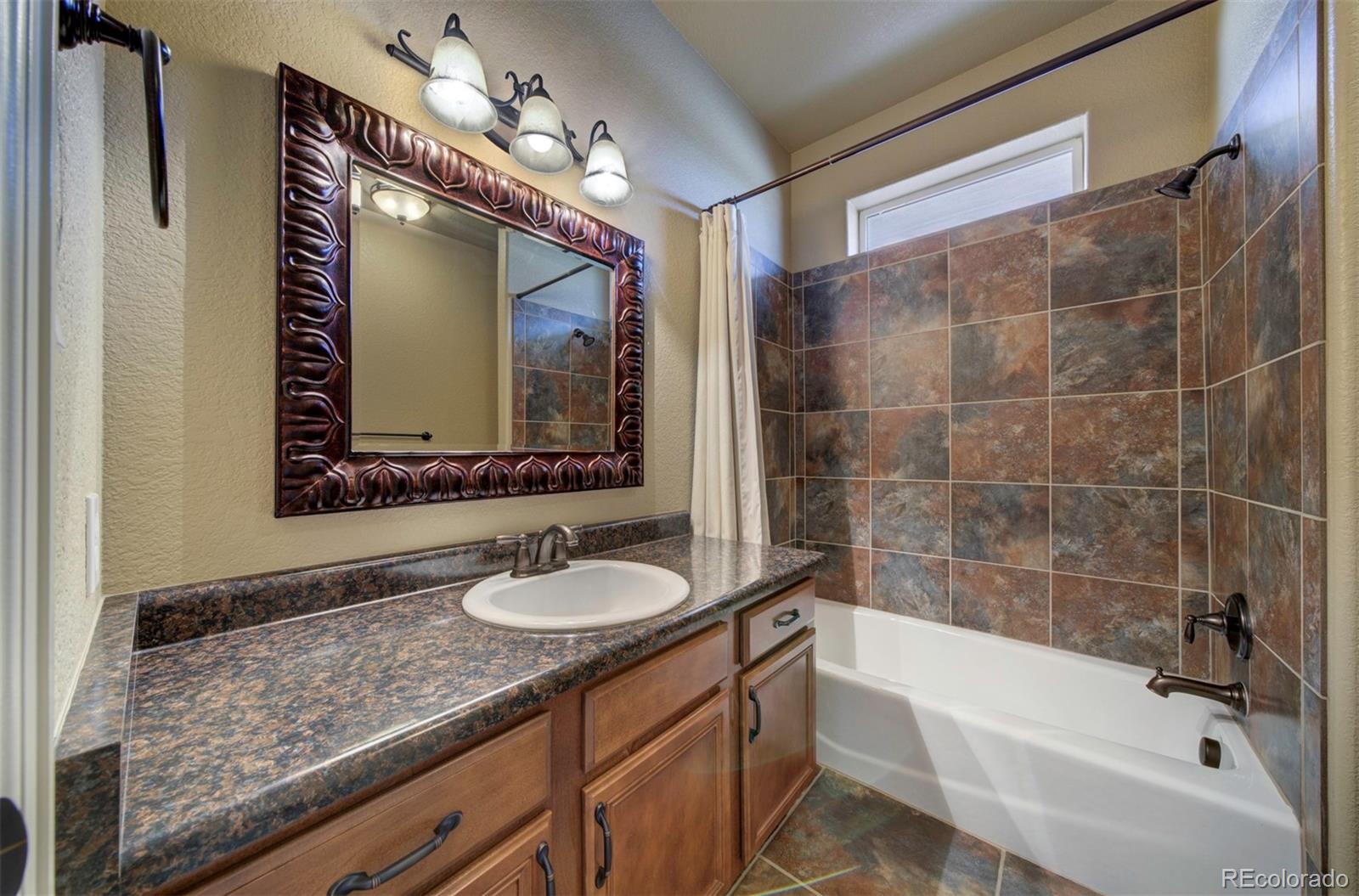 24484 Gale Road Pueblo, CO 81006 - Photo 30 of 43 a bathroom with a granite countertop sink mirror and bathtub