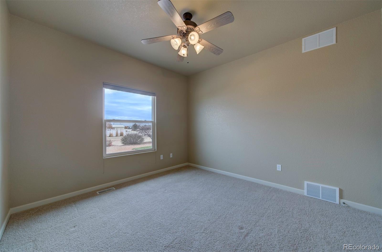 24484 Gale Road Pueblo, CO 81006 - Photo 32 of 43 an empty room with windows and fan
