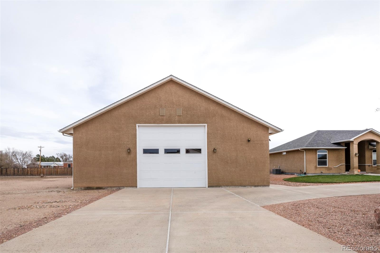 24484 Gale Road Pueblo, CO 81006 - Photo 6 of 43 a front view of a house with a yard and garage
