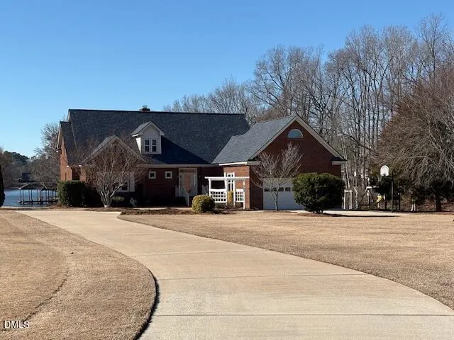 a front view of a house with a yard and trees