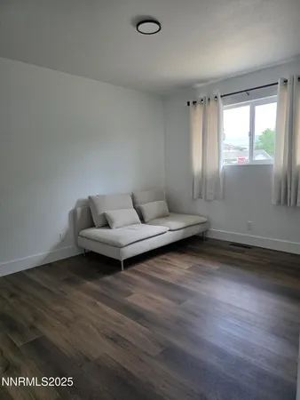 a living room with hard wood floors and a window