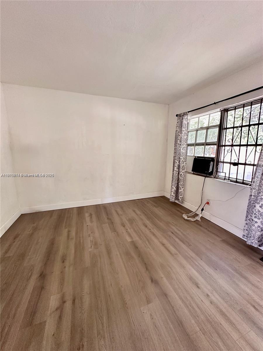 401 Northwest 81st Street Miami, FL 33150 - Photo 3 of 10 an empty room with wooden floor and windows