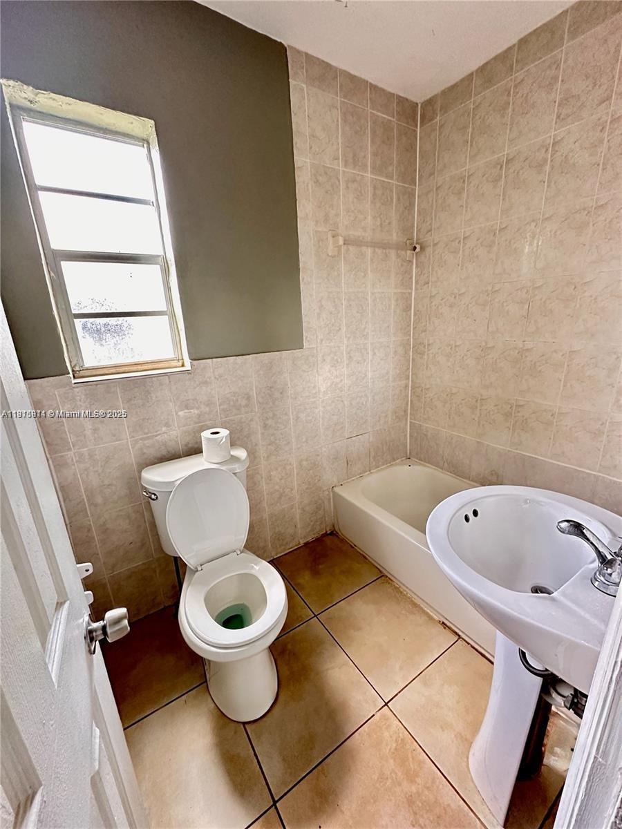 401 Northwest 81st Street Miami, FL 33150 - Photo 7 of 10 a bathroom with a bathtub a toilet and a sink