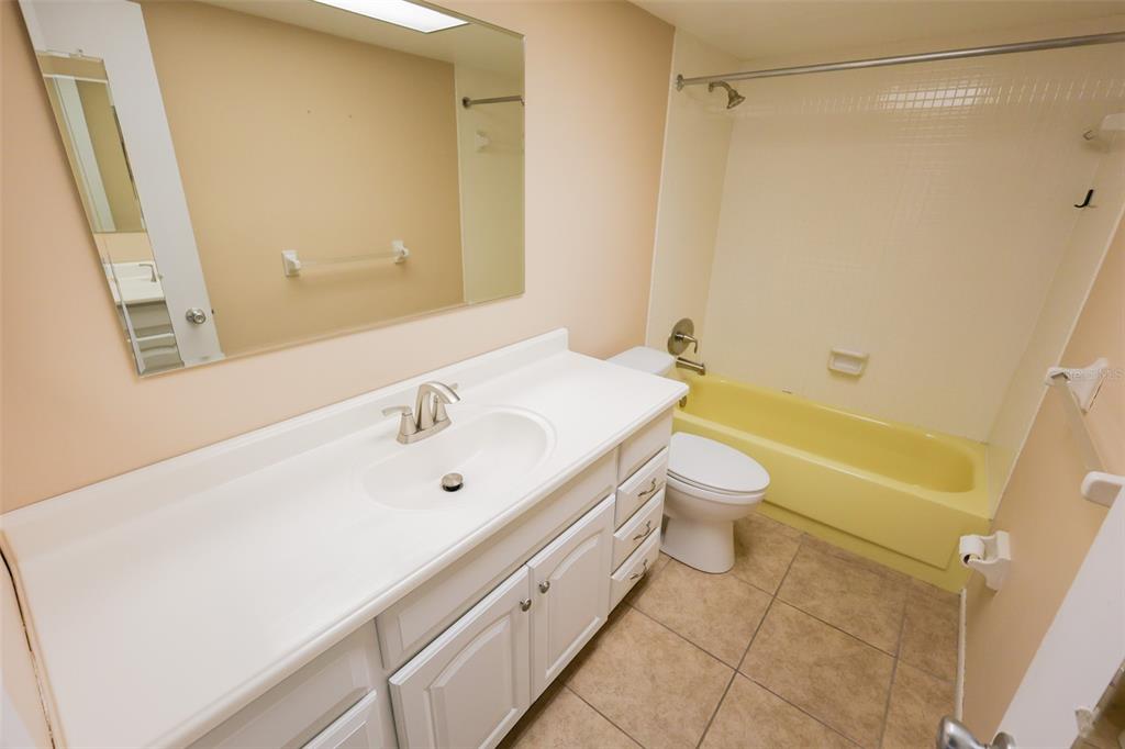 2003 Greenbriar Boulevard, Unit 1 Clearwater, FL 33763 - Photo 15 of 20 a bathroom with a bathtub shower sink vanity and a toilet