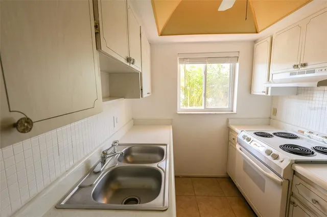 a kitchen that has a sink a stove and window
