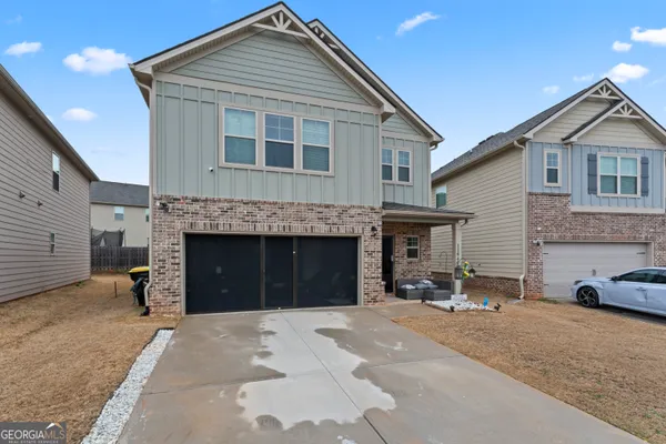 a front view of a house with a yard and a garage