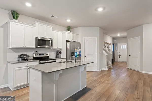 a kitchen with white cabinets and stainless steel appliances